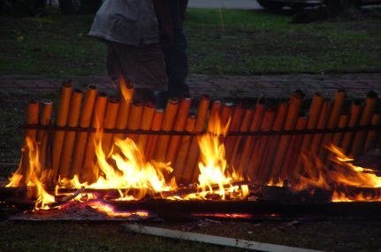 Buluh lemang disusun berhampiran api semasa proses memasak