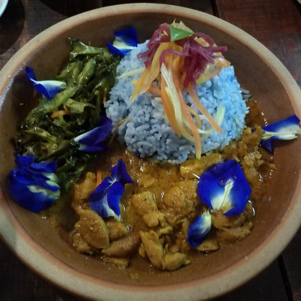 Sepinggan nasi kerabu biru dengan lauk dan ulam