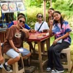 A community merienda gathering in the Philippines with people sharing food
