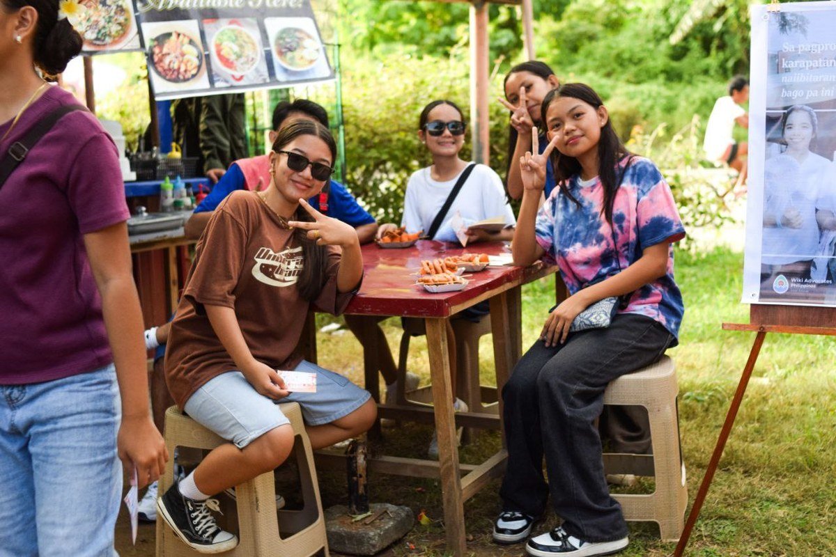 A community merienda gathering in the Philippines with people sharing food