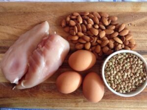 A selection of protein-rich foods including eggs, chicken, almonds and lentils