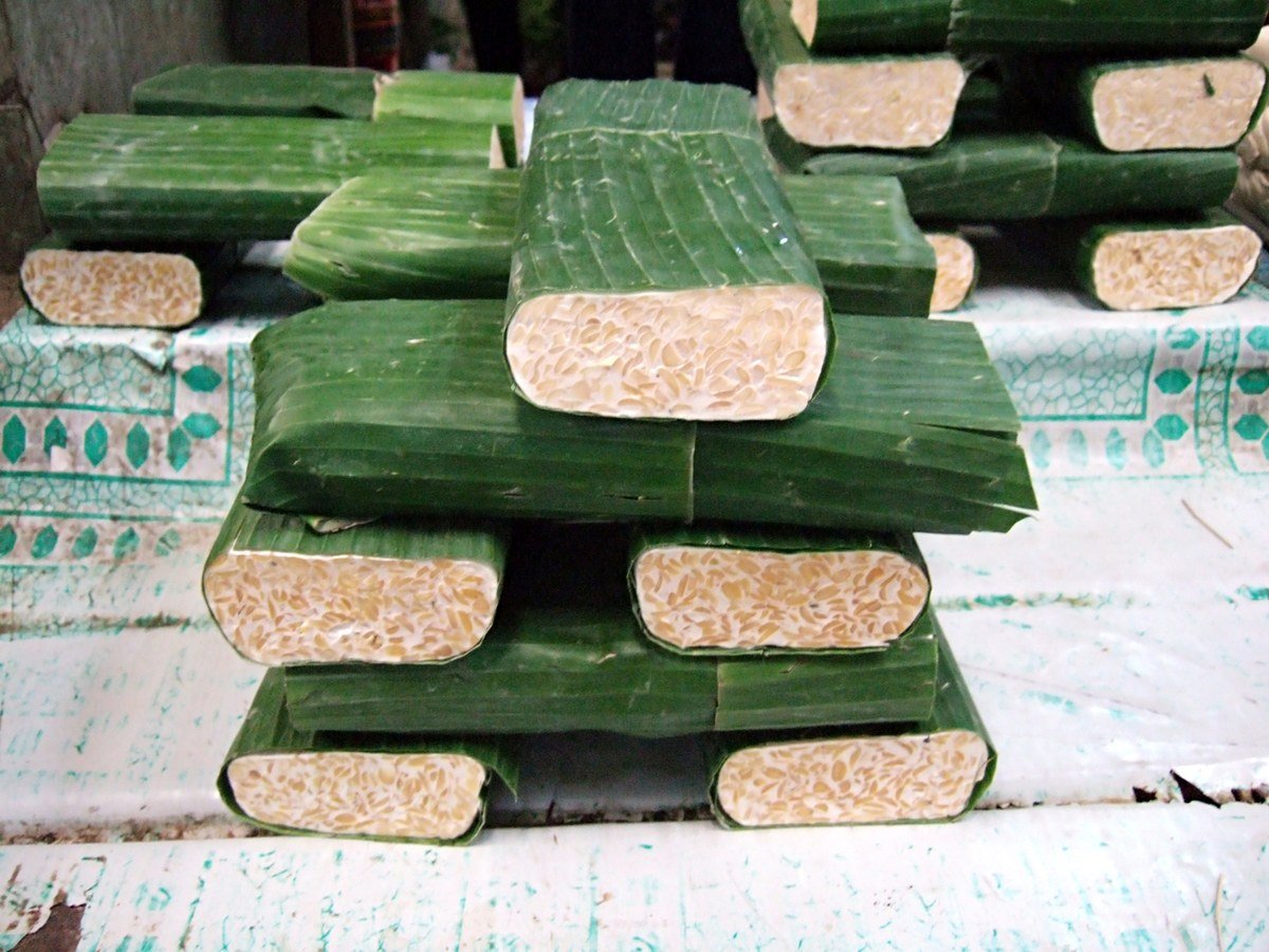 Fresh tempeh wrapped in banana leaves at a Jakarta market