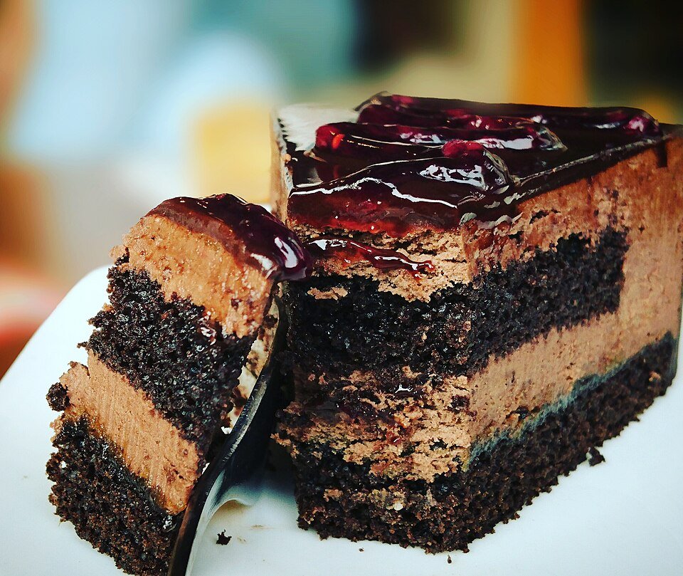 Hirisan kek coklat berlapis dengan krim coklat di atas pinggan putih