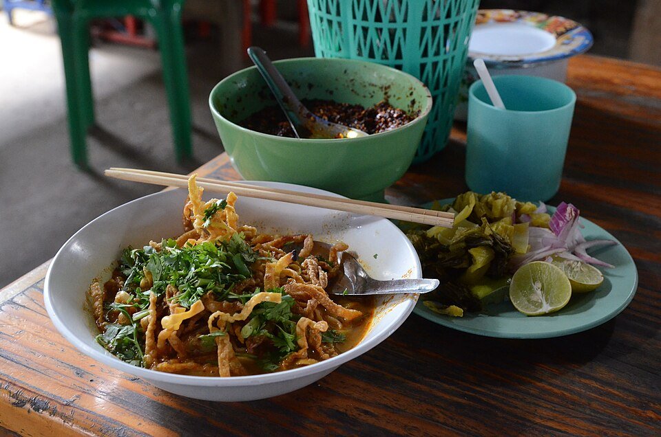 Khao soi with chicken, crispy noodles and condiments in Chiang Mai