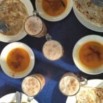 Roti canai bersama kari dan teh tarik di sebuah kedai Malaysia