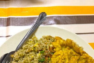Sepinggan nasi goreng kampung dengan telur dadar dan semangkuk sup.