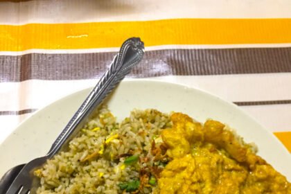 Sepinggan nasi goreng kampung dengan telur dadar dan semangkuk sup.