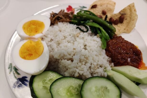 Nasi lemak buatan rumah dengan sambal, telur rebus, timun, ikan bilis dan sayur.