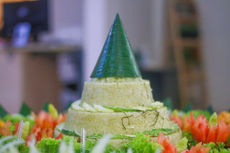 Indonesian community members gathered around tumpeng at a celebration
