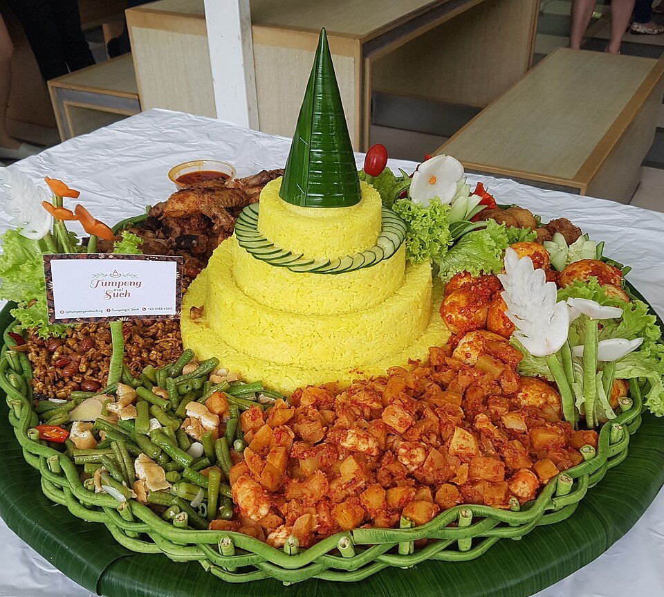 Indonesian tumpeng with yellow rice and assorted savoury side dishes