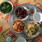 An everyday Vietnamese family meal arranged on a round metal tray