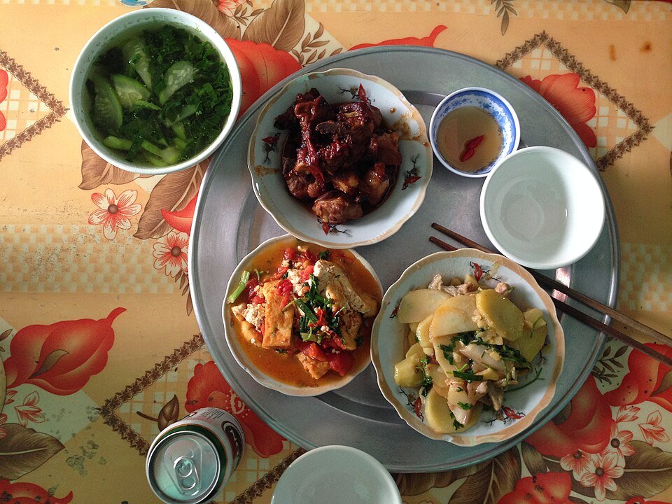 An everyday Vietnamese family meal arranged on a round metal tray