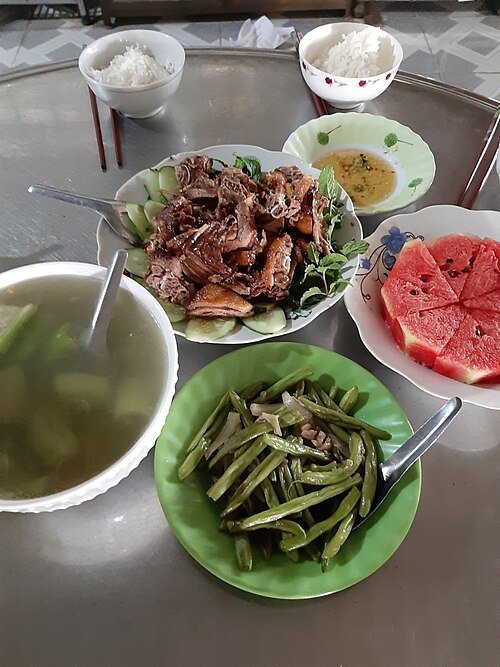 A Vietnamese home meal with braised duck, vegetables, soup and fish sauce