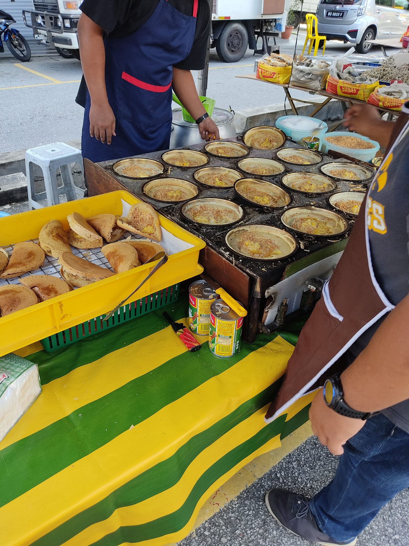 Penjual menyediakan apam balik kecil dalam acuan bulat