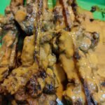 Ayam percik bersalut kuah di atas lidi pemanggang