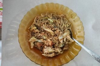 Bihun goreng ayam dengan sayur dan telur di atas pinggan