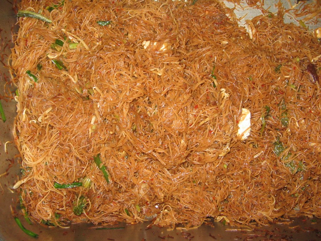 Bihun goreng kicap dalam dulang besar dengan sayur hijau yang sudah digaul rata