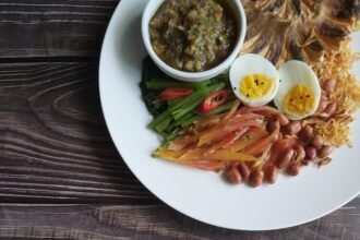 Bubur nasi Malaysia bersama telur rebus, ikan, sambal dan sayuran