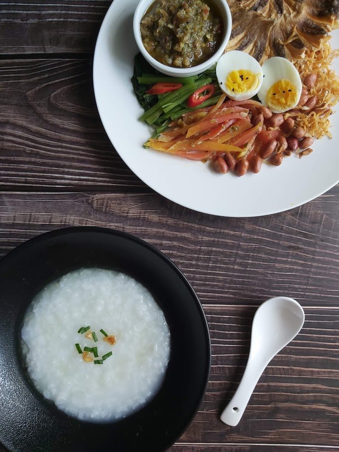 Bubur nasi Malaysia bersama telur rebus, ikan, sambal dan sayuran