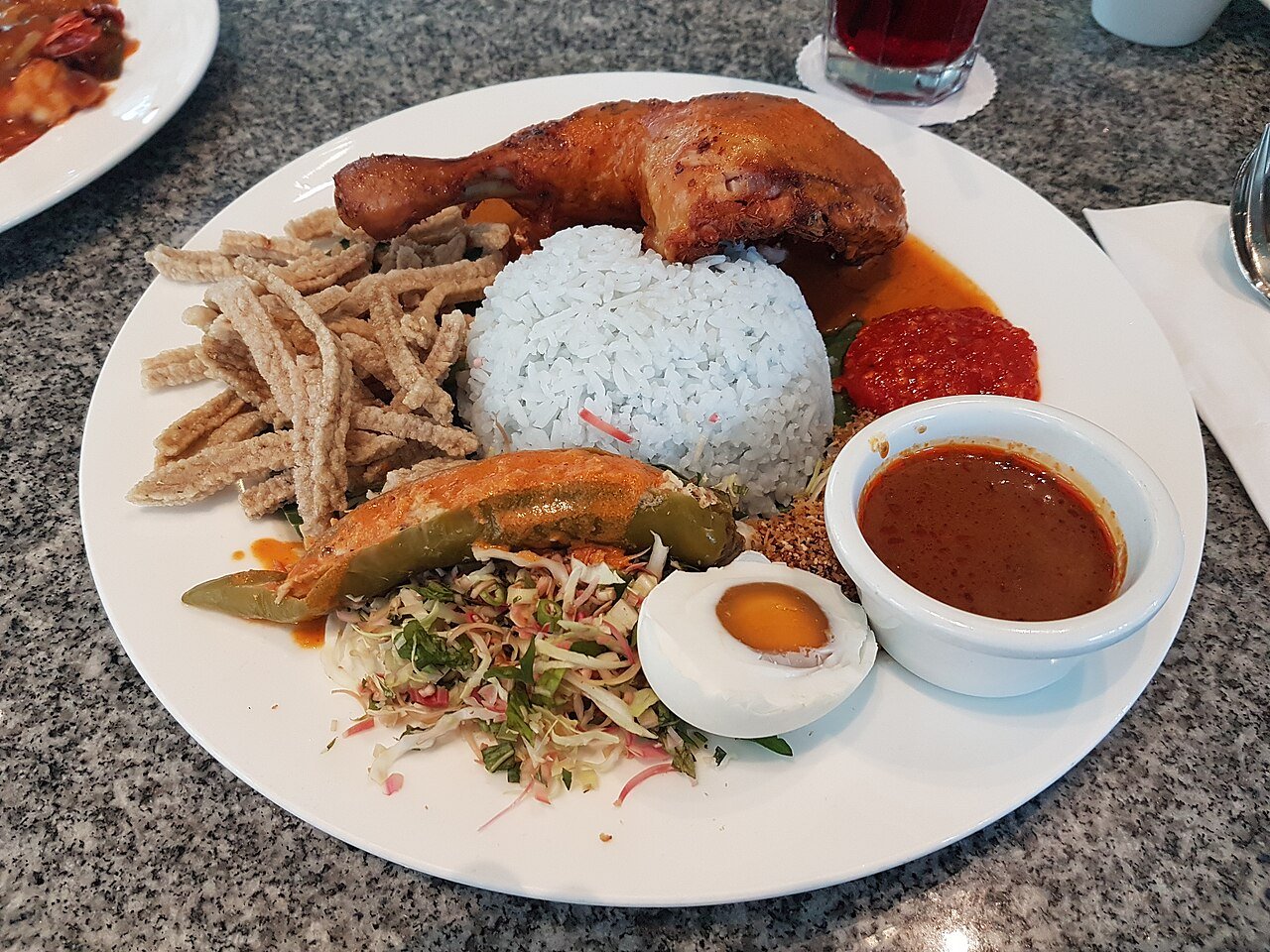 Sepinggan nasi kerabu biru bersama ulam dan lauk