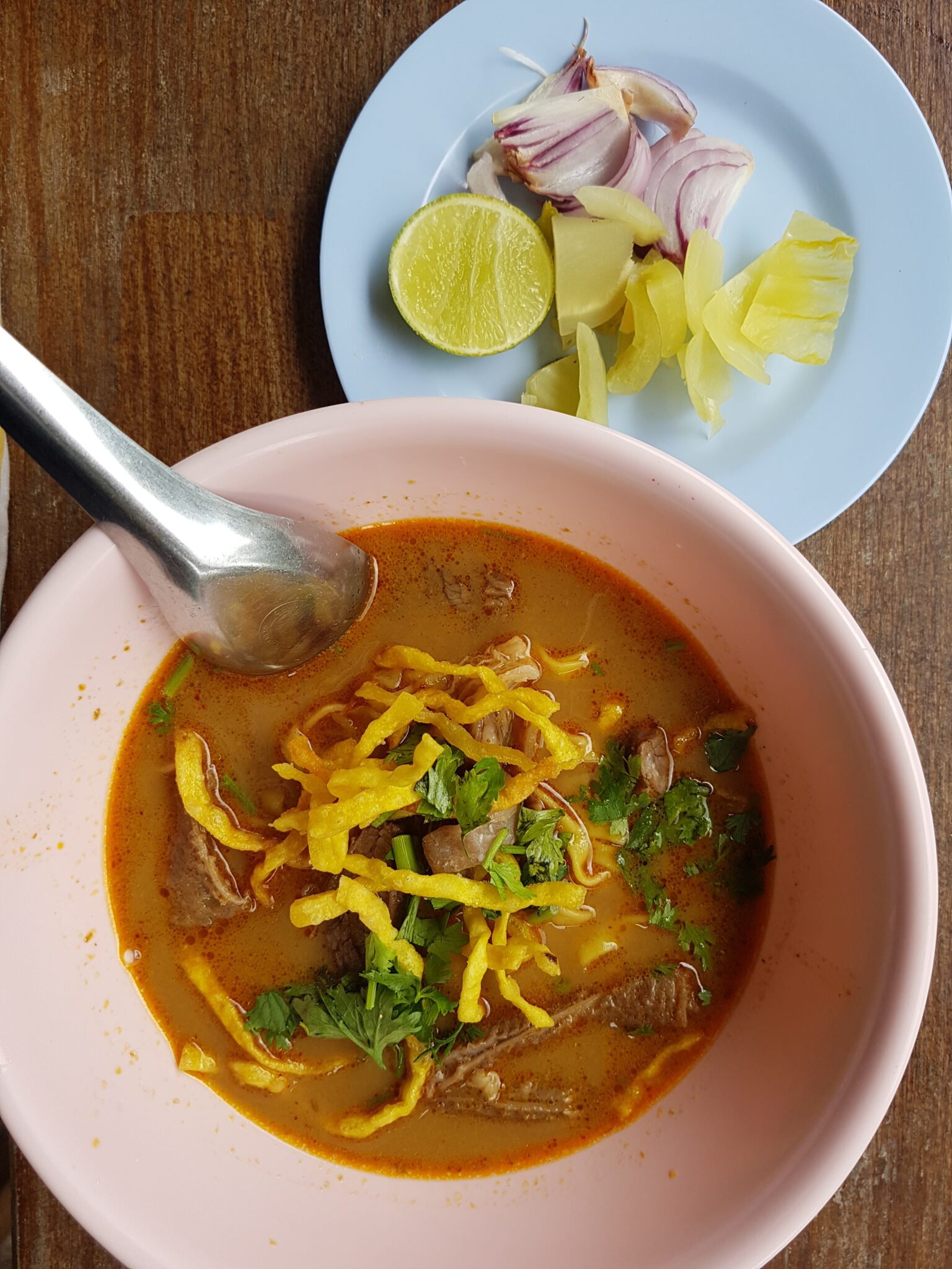 Beef khao soi in Chiang Mai with crisp noodles and condiments