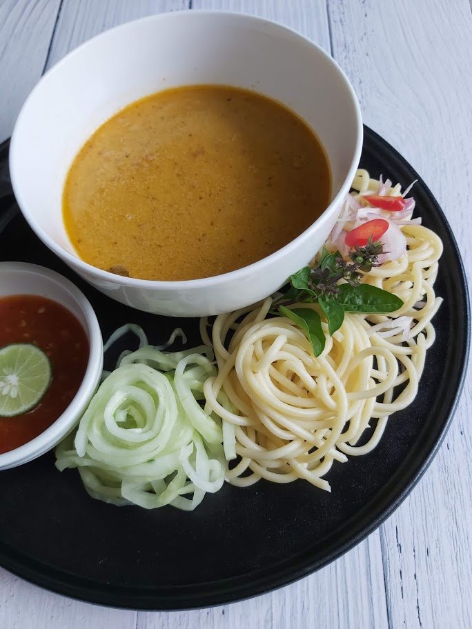 Pandangan dekat kuah Laksa Johor, spageti, timun dan sambal belacan