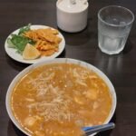 A bowl of mohinga with rice noodles, fritters, herbs and lime served at a Burmese restaurant