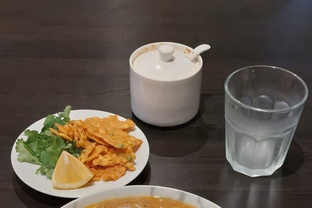 A bowl of mohinga with rice noodles, fritters, herbs and lime served at a Burmese restaurant