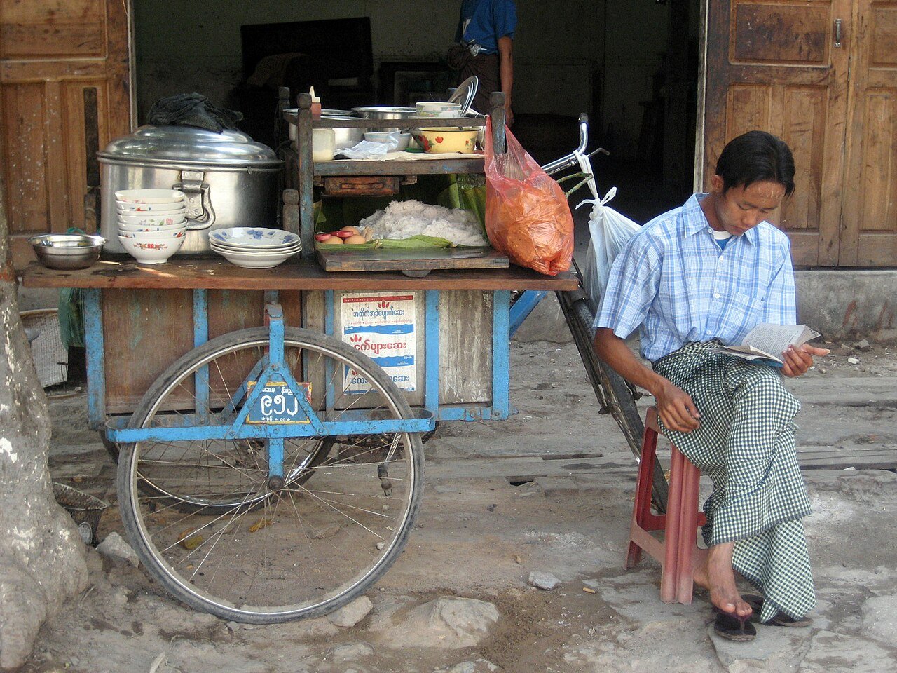 Mohinga street stall with a soup pot, noodles and bowls in Mandalay, Myanmar