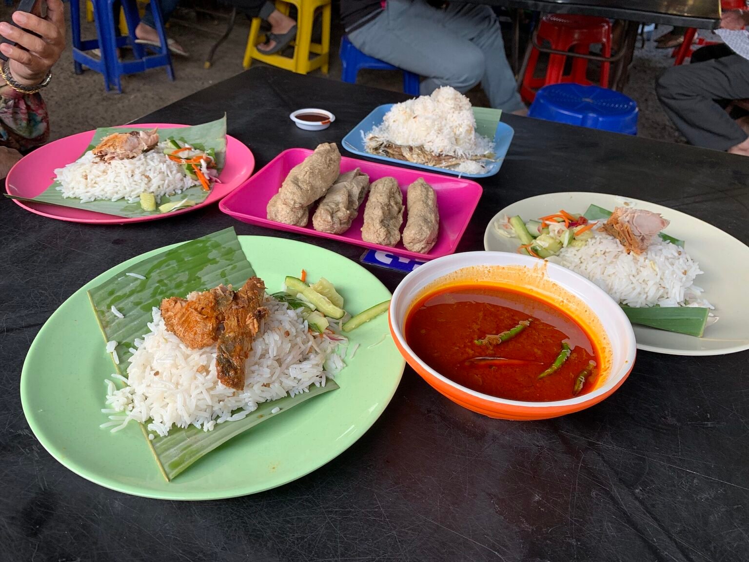 Beberapa pinggan nasi dagang dengan acar, gulai ikan dan keropok lekor di Terengganu