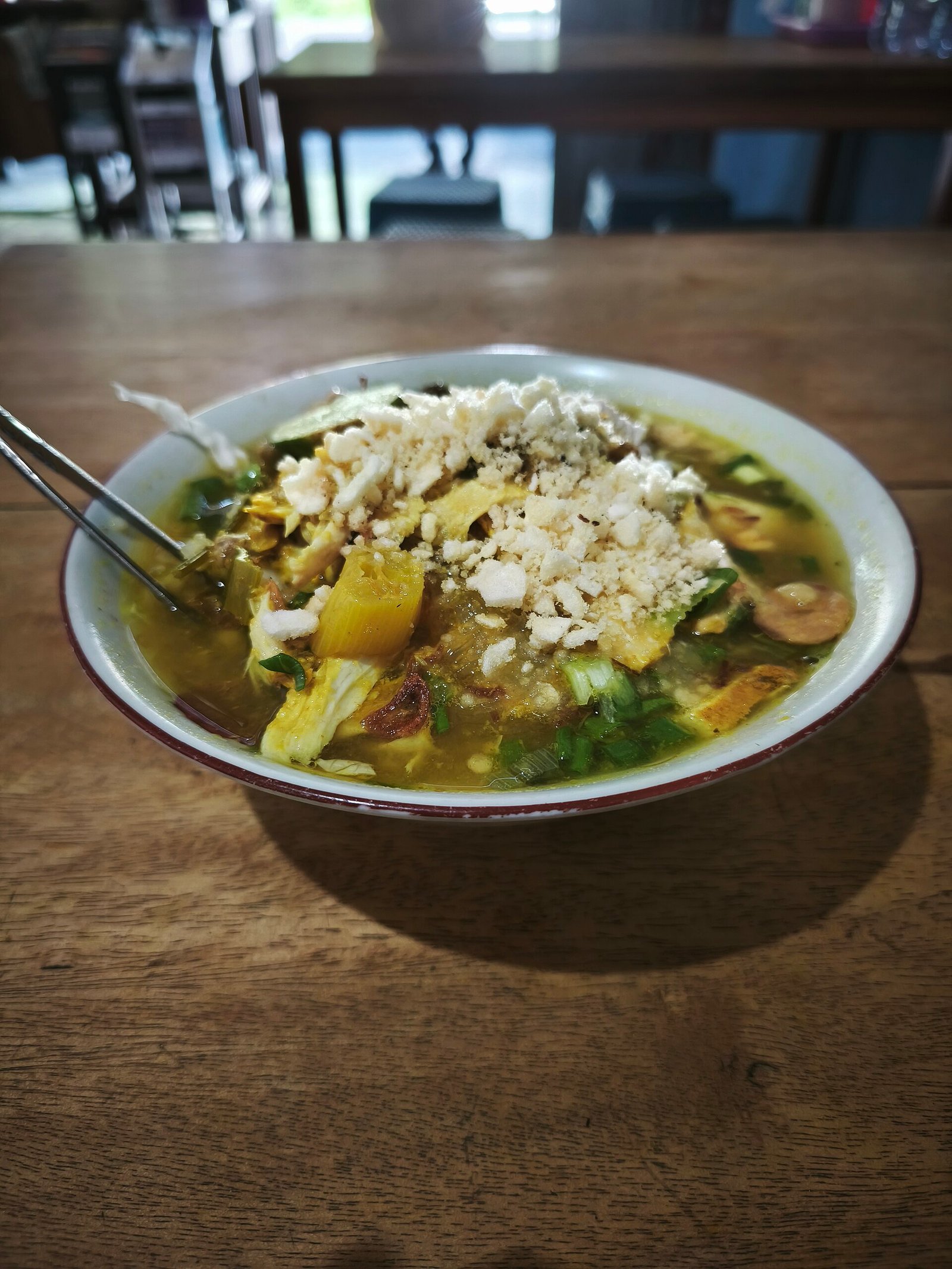 Bowl of Soto Lamongan with chicken and a generous mound of koya