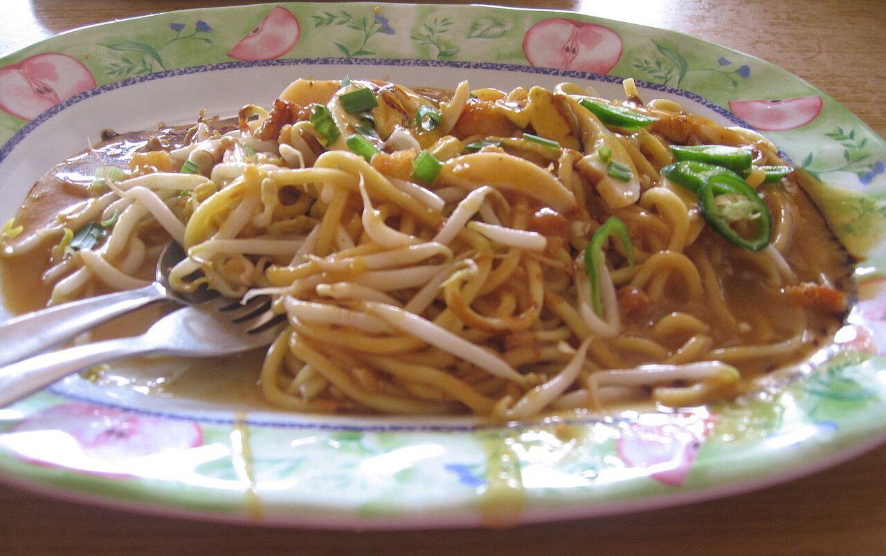 Semangkuk mee rebus dengan kuah dan pelengkap