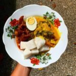 Semangkuk lontong kuah lodeh dengan sayur dan nasi impit