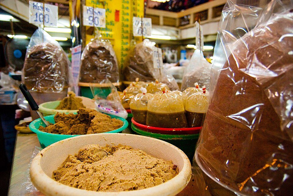 Baskets of shrimp paste and sealed fermented fish products at Warorot Market