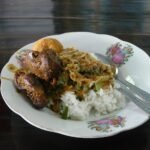 Madiun-style nasi pecel with rice, vegetables and sides, photographed in Malang