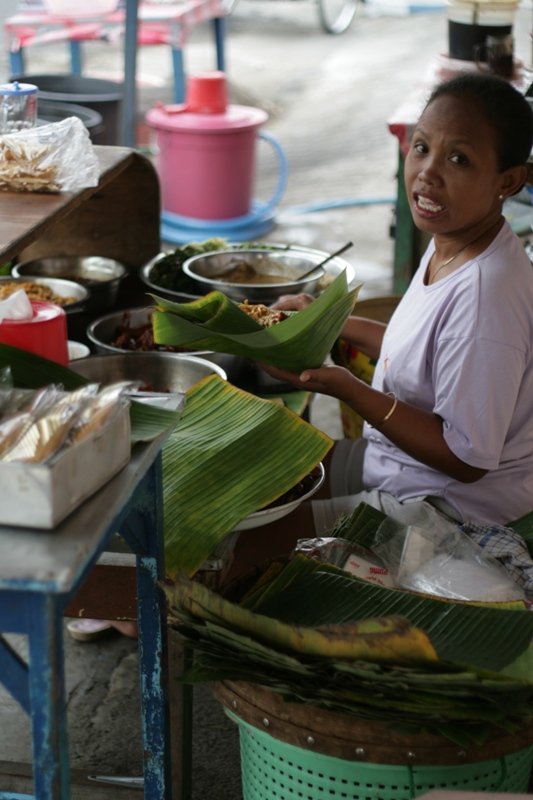 Pecel seller preparing a banana-leaf serving in Madiun